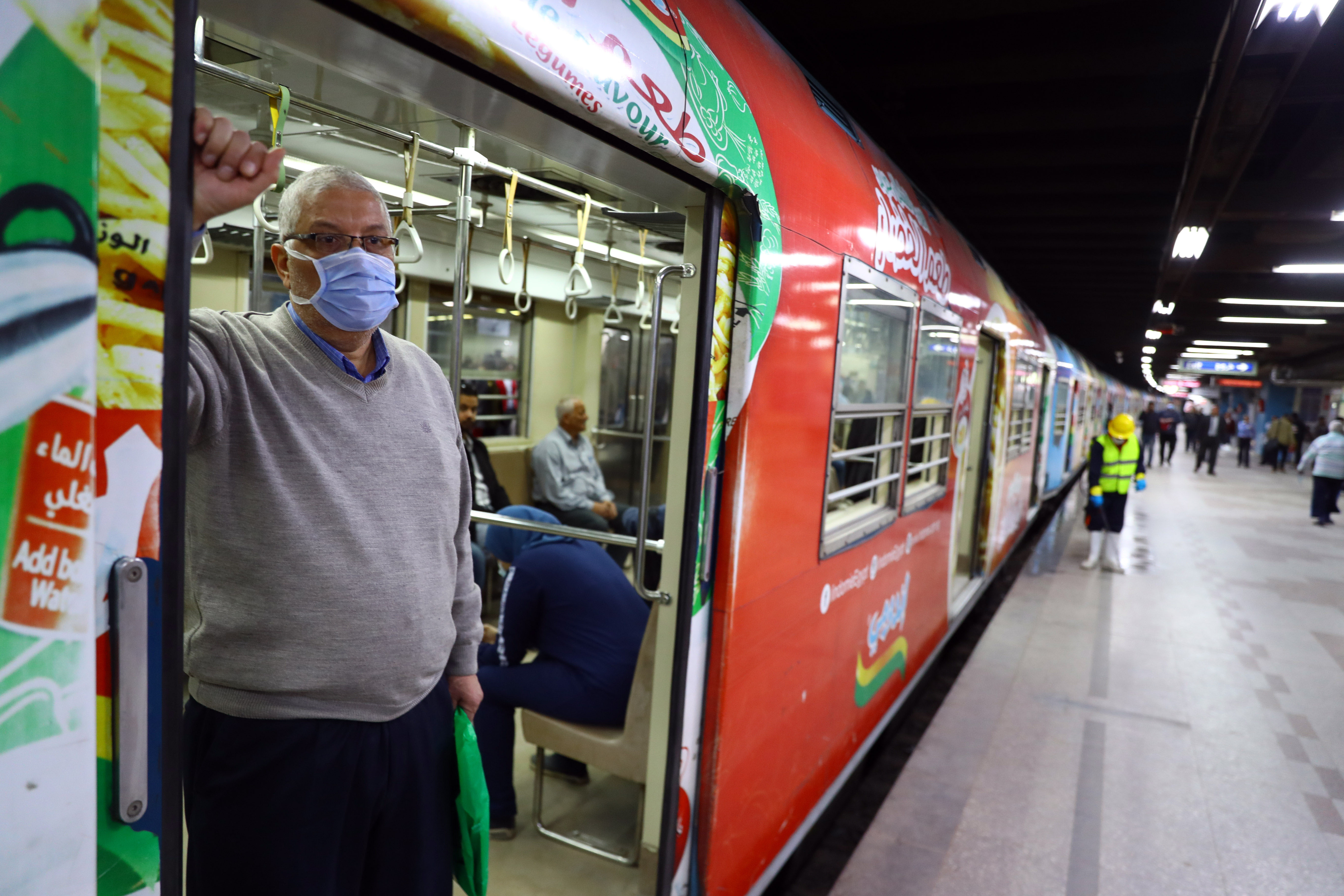 Man wearing a face mask stands in the doorway of public transportation