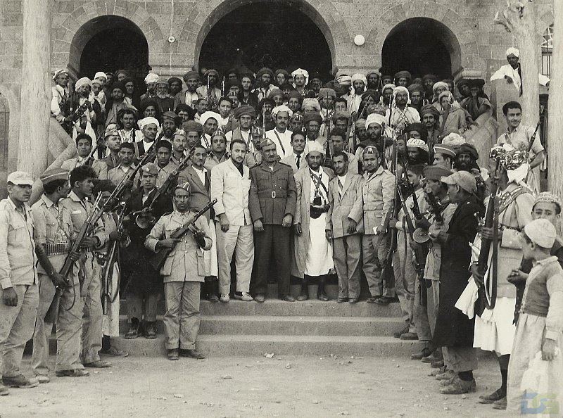 President Abdullah Al-Sallal, Dr. Al-Baidani, Amin Noaman, Sinan Abu Lahoum, Abdullah Al-Dhabi, Muhammad Al-Faseel and Ahmed Al-Marouni pose at the Republican Palace in the wake of the September 26 Revolution in the North of Yemen (Source: Wikimedia Commons).