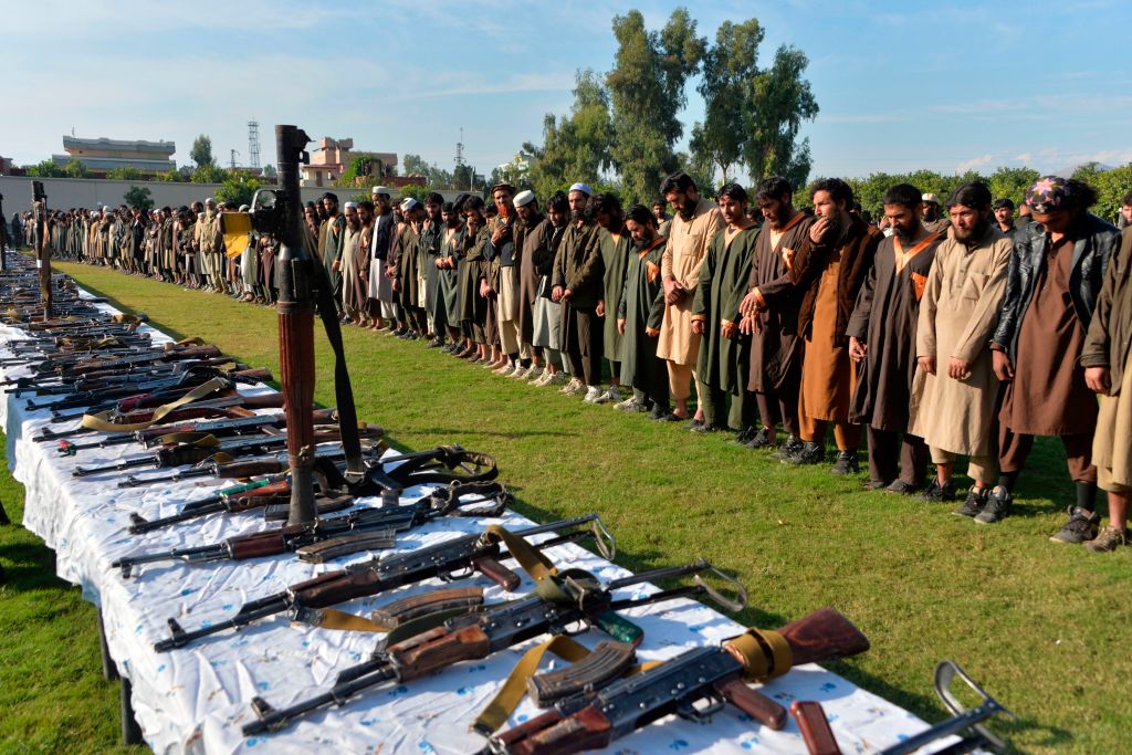 In this photograoh taken on November 17, 2019 members of the Islamic State (IS) group stand alongside their weapons, following they surrender to Afghanistan's government in Jalalabad, capital of Nangarhar Province. 