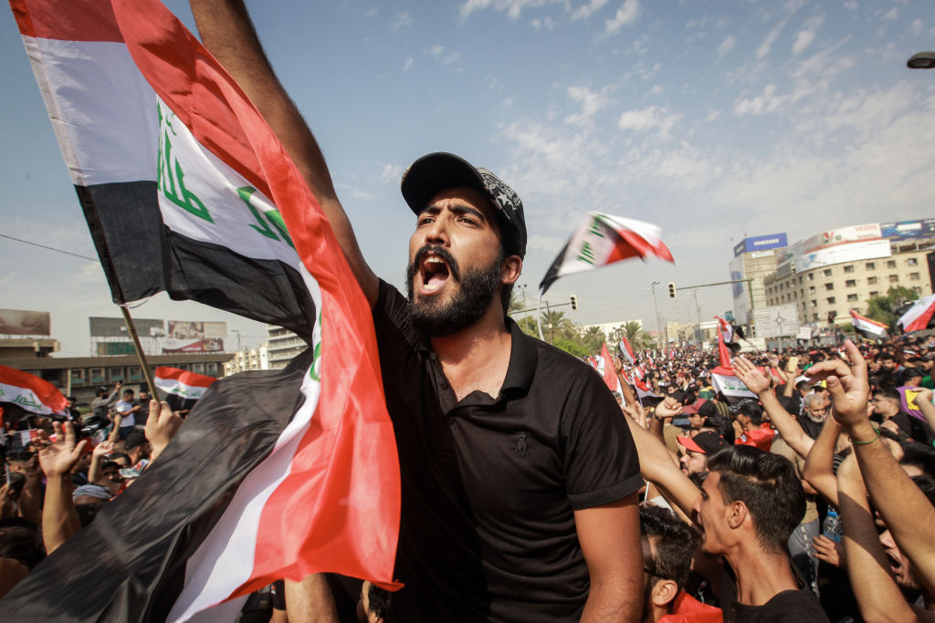 Protesters shout slogans during an anti-government demonstration against the provision of jobs and the alleged government corruption, in Tahrir Square in central Baghdad. 