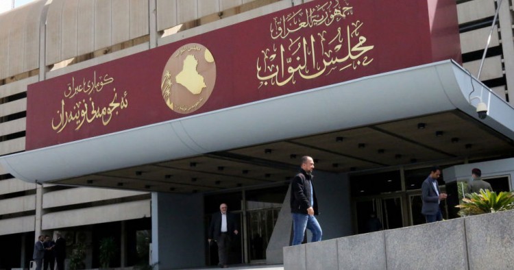 Iraqis stand outside the Council of Representatives in Baghdad's Green Zone on February 27, 2020 (Photo by SABAH ARAR/AFP via Getty Images)