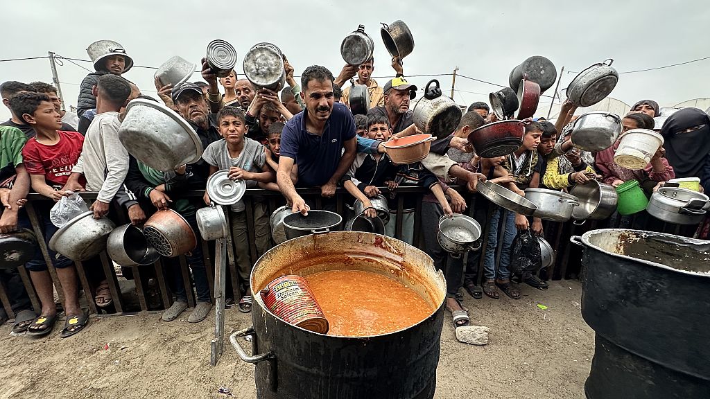Palestinians wait with empty pots and pans in their hands to receive meals distributed by charitable organizations at al-Mawasi in Khan Yunis, Gaza, on April 2, 2025. Photo by Doaa Albaz/Anadolu via Getty Images
