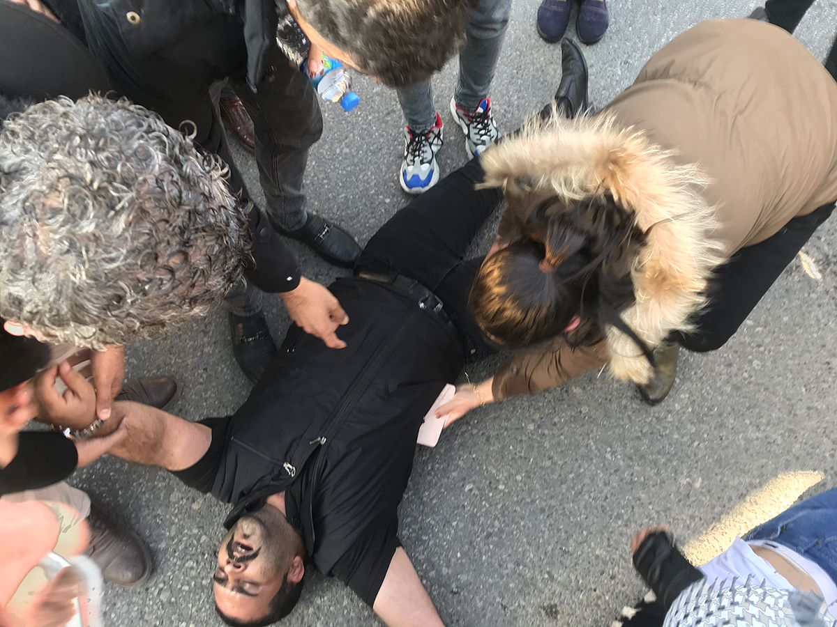 Demonstrators try to help someone affected by tear gas after security forces intervene during protests over deteriorating economic conditions in Sulaymaniyah on Dec. 11, 2020. (Photo by Fariq Faraj Mahmood/Anadolu Agency via Getty Images)