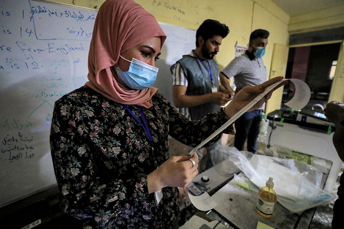 Iraqi election officials conduct the electronic count of votes at a polling station in the capital Baghdad's Sadr City district, during the early parliamentary elections on October 10, 2021. (Photo by AHMAD AL-RUBAYE/AFP via Getty Images)