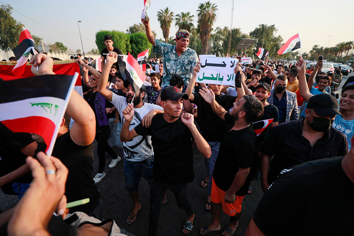 A protester lifts a placard bearing the slogan “no solution but dissolution” during an anti-government demonstration calling for the dissolution of the Iraqi parliament in Baghdad on September 9, 2022. Photo by AHMAD AL-RUBAYE/AFP via Getty Images.