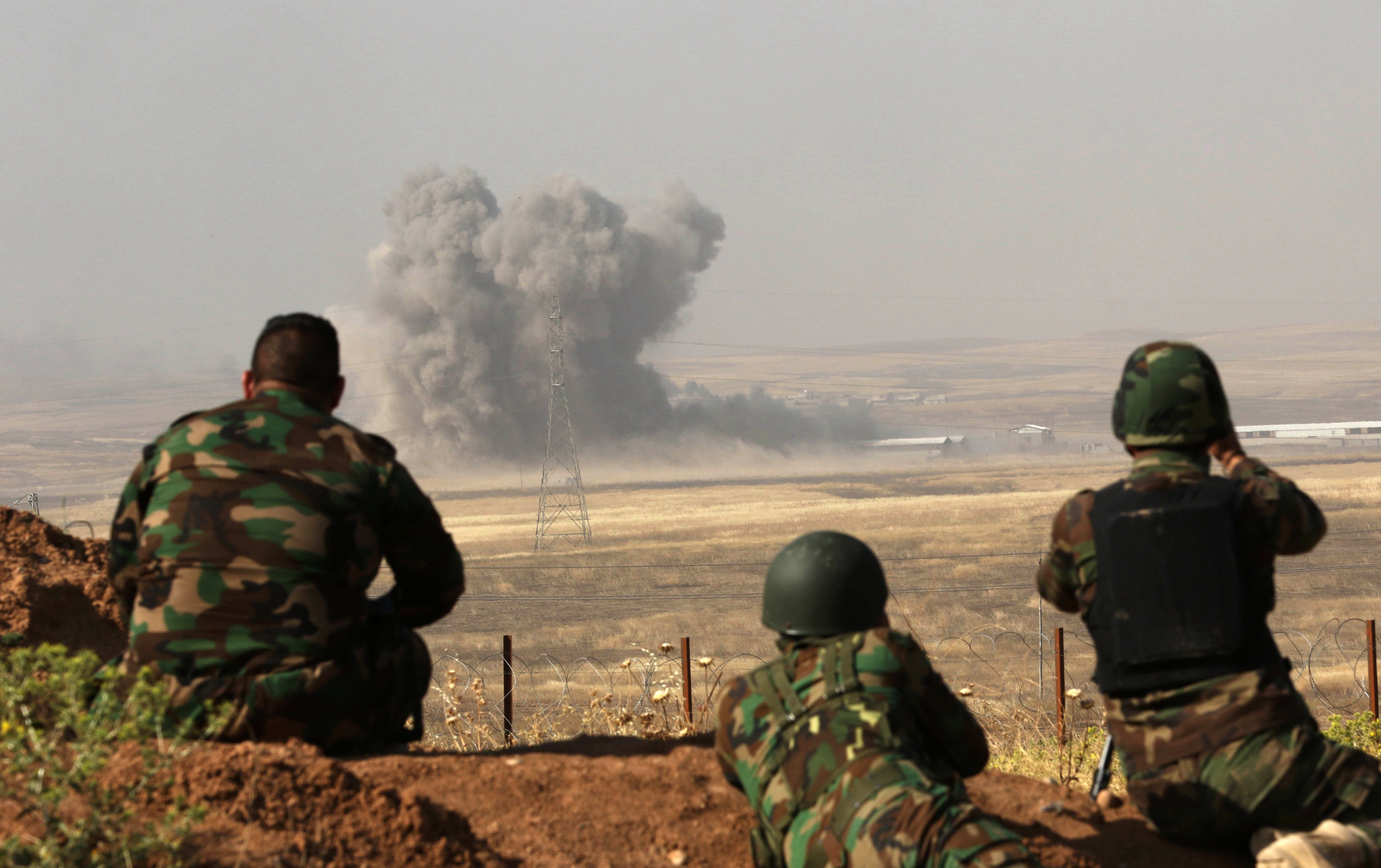 Smoke billows on the front line as Iraqi Kurdish Peshmerga fighters hold a position near Hasan Sham village, 45 km east of the city of Mosul, during an operation aimed at retaking areas from ISIS on May 29, 2016. Photo by SAFIN HAMED/AFP via Getty Images.