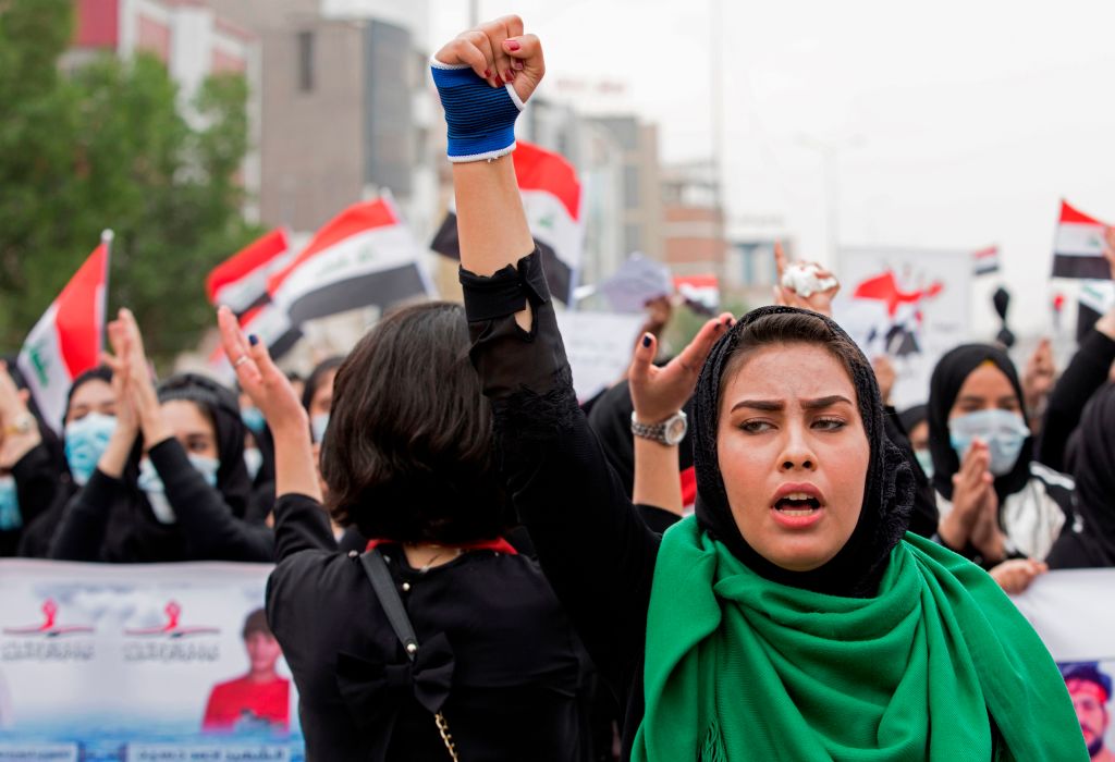 An Iraqi woman raises her fist as she takes part in an anti-government march in the center of the southern city of Basra on December 2, 2019.