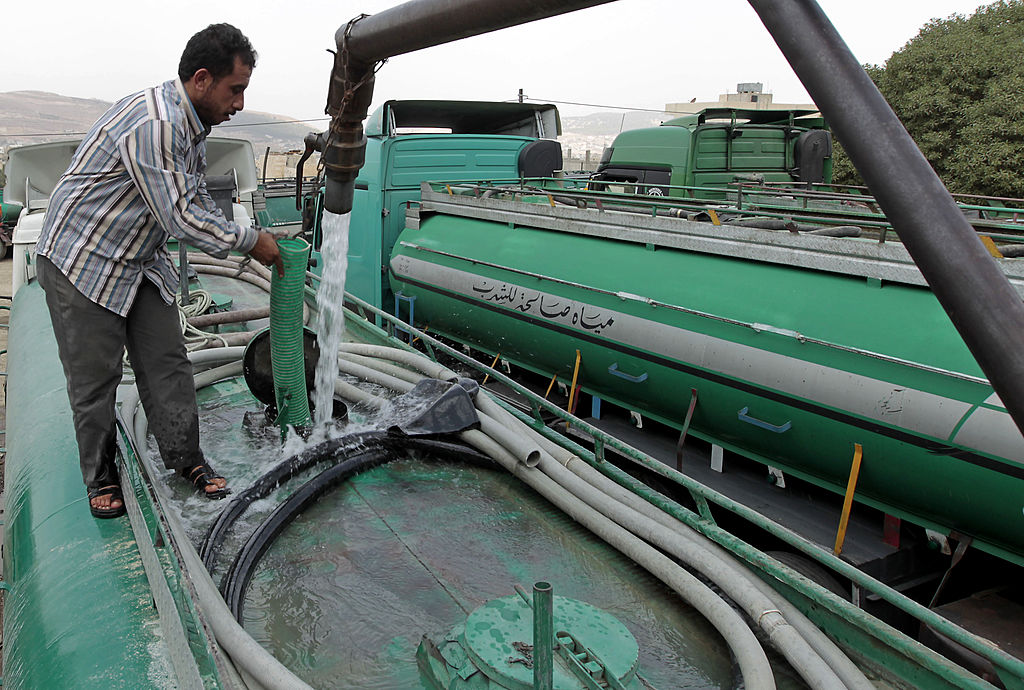 A Jordanian truck driver fills his tanker with water in Abu Nuseir near the capital Amman. (KHALIL MAZRAAWI/AFP/GettyImages)