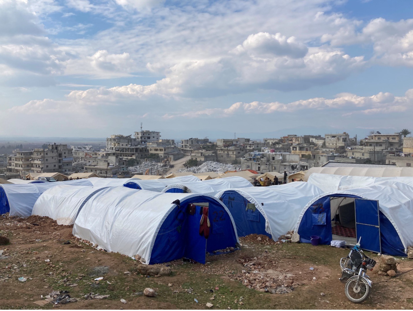 A new displaced persons camp in central Harem, adjacent to a block of collapsed apartment buildings. Photo by Gregory Waters.