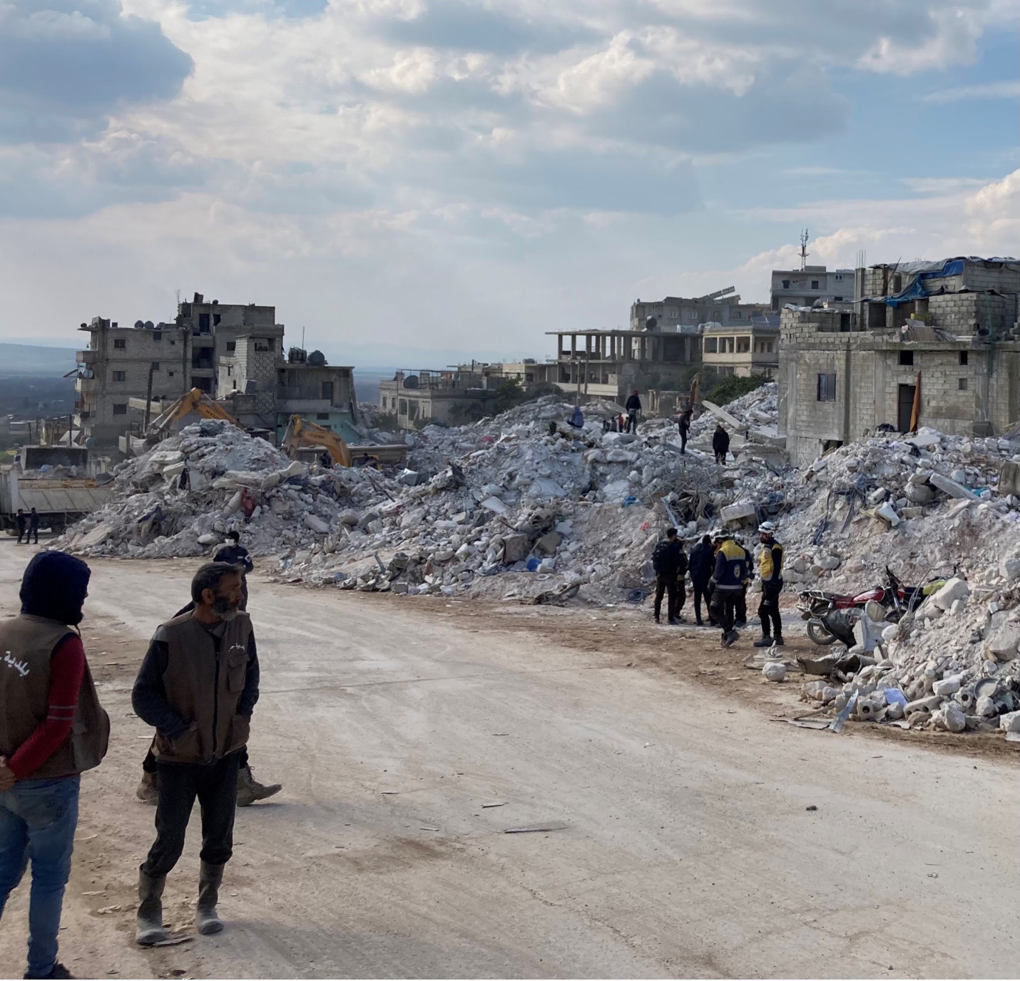 White Helmets and local municipal workers join town residents digging through the rubble five days after the quake. Hundreds of people were killed when their homes collapsed on them in this block in Harem.