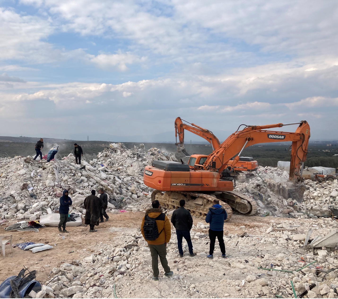 A family sifts through the rubble of their apartment building outside Harem looking for blankets and clothes to salvage.