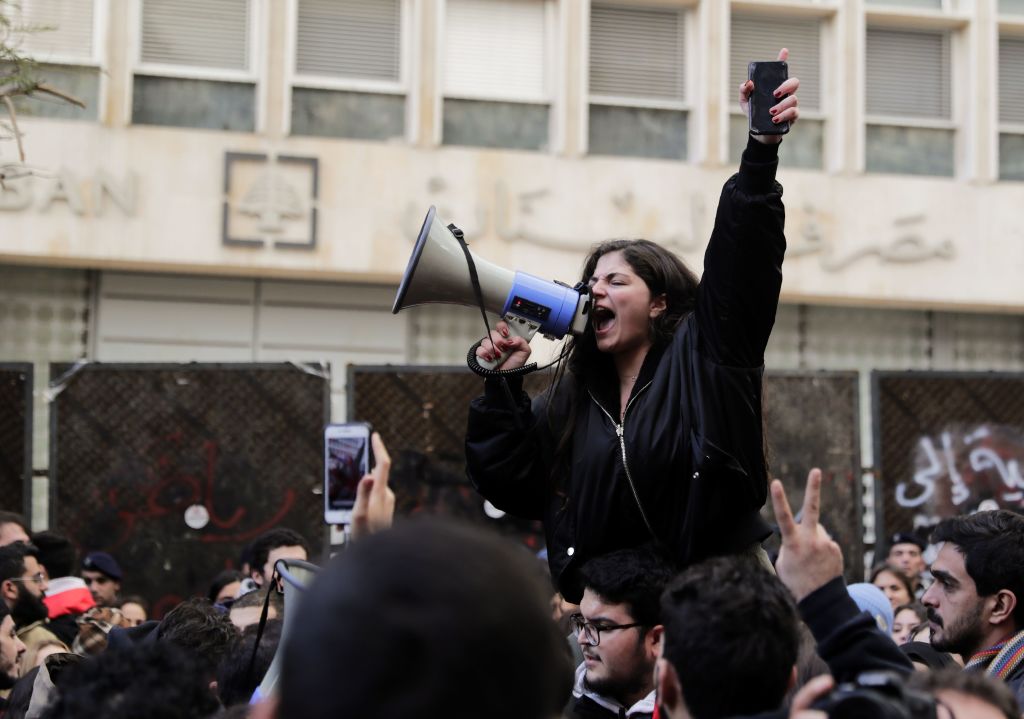 A Lebanese anti-government demonstrator yells slogans as she takes part in a rally in front of the central bank building in the capital Beirut on December 30, 2019. - A liquidity crunch has pushed Lebanese banks to impose capital controls on US dollar accounts, capping withdrawals at around $1,000 a month. As a result, the value of the Lebanese pound against the dollar has dropped by around 30 percent on the unofficial market, leading prices to rise. (Photo by ANWAR AMRO / AFP) (Photo by ANWAR AMRO/AFP via Getty Images)