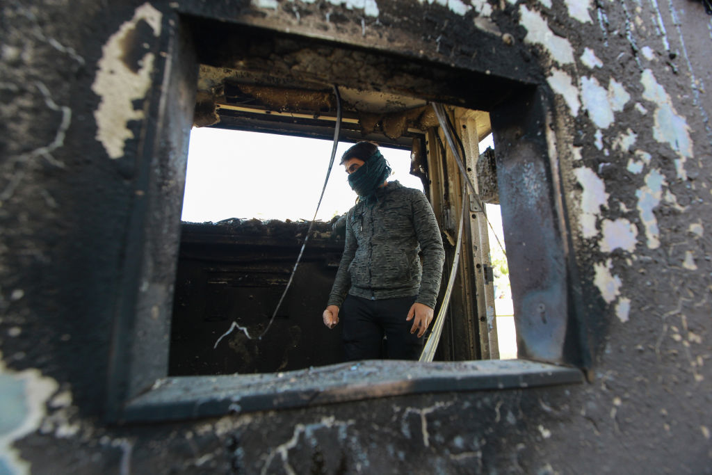  A protester stands inside a burned checkpoint during the sit-in against deadly US airstrikes on sites of a Shiite militia in front of the US embassy. Iraqi mourners on Tuesday stormed the building of the US embassy in Baghdad's heavily fortified Green Zone.