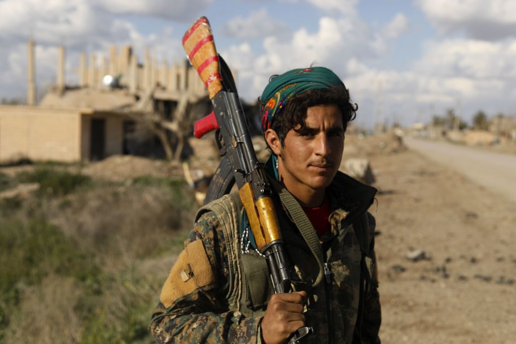 A fighter of the US-backed Syrian Democratic Forces (SDF) takes a rest in the frontline Syrian village of Baghouz on February 18, 2018.