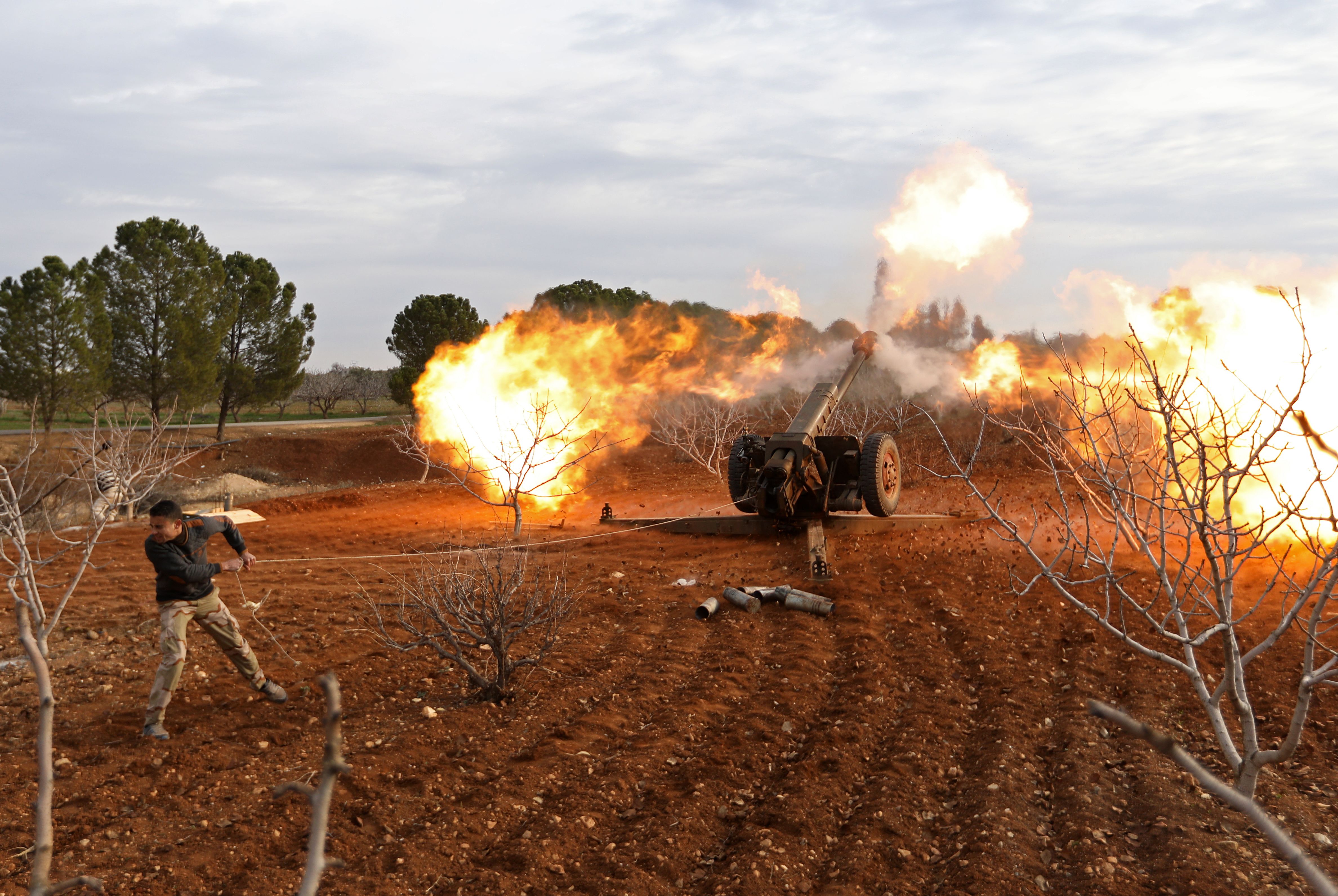 An opposition fighter fires a gun from a village near al-Tamanah during ongoing battles with government forces in Syria’s Idlib province. (OMAR HAJ KADOUR/AFP/Getty Images)