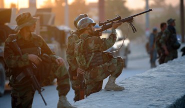 An Afghan soldier aims his gun as he guards the area surrounding the Intercontinental hotel during a military operation against Taliban militants that stormed the hotel in Kabul on June 29, 2011.