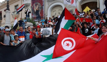 Tunisian protestors wave their national and the Syrian flags on May 6, 2013. 