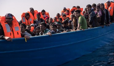 Migrants and refugees are assisted by members of the Spanish NGO Proactiva Open Arms as they crowd on board of a wooden boat sailing out of control at 20 miles (38 km) north of Sabratha, Libya on February 18, 2017.