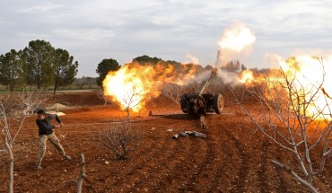 An opposition fighter fires a gun from a village near al-Tamanah during ongoing battles with government forces in Syria's Idlib province on January 11, 2018