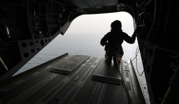 August 2018: An Emirati soldier watching from a military plane a ship crossing through the strategic strait of Bab al-Mandab