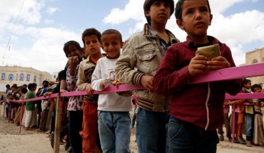 Yemeni children queue to obtain dinner meal distributed as aids by a local charity, the Amalona organization, on May 18, 2019 in Sana’a, Yemen. 