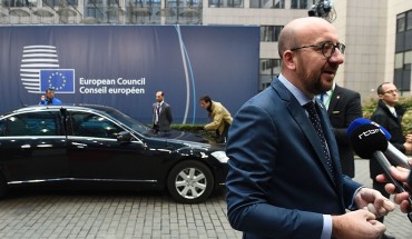 Belgium's Prime minister Charles Michel (R) addresses journalists as he arrives for the second day of an European Union leaders summit to discuss Syria, relations with Russia, trade and migration, on October 21, 2016 at the European Council, in Brussels
