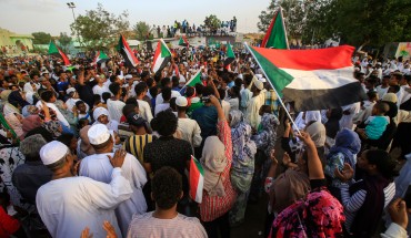 Sudanese people chant slogans and wave national flags as they celebrate after protest leaders struck a deal with the ruling generals on a new governing body, in the capital Khartoum's eastern district of Burri on July 5, 2019, - The deal, reached in the early hours of July 5 after two days of hard-won talks brokered by Ethiopian and African Union mediators, provides for the interim governing body to have a rotating presidency, as a compromise between the positions of the generals and the protesters. The blu