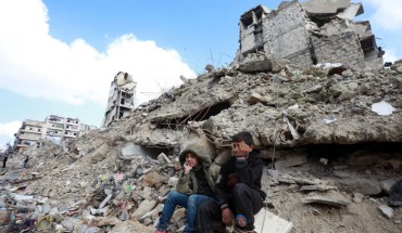 Children sit on the rubble of buildings in Aleppo, Syria.