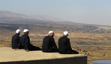 Cover photo: Druze men in the Israeli-annexed Golan Heights look out across the southwestern Syrian province of Quneitra, visible across the border on July 7, 2018. (Photo by JALAA MAREY/AFP/Getty Images)