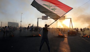 An Iraqi protester waves the national flag during a demonstration against state corruption, failing public services, and unemployment, in the Iraqi capital Baghdad on October 5, 2019.