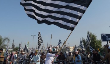 An activists of the Jamiat Ulema-e-Islam waves the party flag during the anti-government "Azadi March" towards Islamabad, in Peshawar on October 27, 2019.