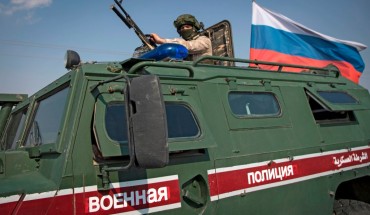 A soldier rides atop a Russian military vehicle near the Syrian northeastern city of Qamishli on October 26, 2019. 