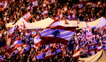 Lebanese anti-government protesters wave national flags as they take part in an anti-govenment demonstration in the capital Beirut's downtown district on November 3, 2019. 