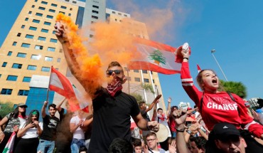 Lebanese students wave the national flag and chant slogans as they gather outside the Ministry of Education and Higher Education during ongoing anti-government protests, in the capital Beirut on November 8, 2019.