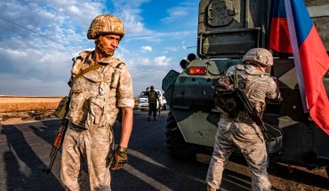 TOPSHOT - Russian military police members stand outside an armoured personnel carrier (APC) along a road in the countryside near the northeastern Syrian town of Amuda in Hasakeh province on October 24, 2019, as part of a joint patrol between Russian forces and Syrian Kurdish Asayish internal security forces near the border with Turkey. - Russian forces have started patrols along the flashpoint frontier, filling the vacuum left by a US troop withdrawal that effectively returned a third of the country to the 