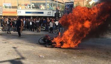 Iranian protesters gather around a burning motorcycle during a demonstration against an increase in gasoline prices in the central city of Isfahan, on November 16, 2019.