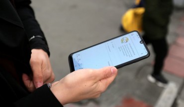 A woman holds a smartphone shown to be unable to access internet, while standing along a street in the Iranian capital Tehran on November 23, 2019. 