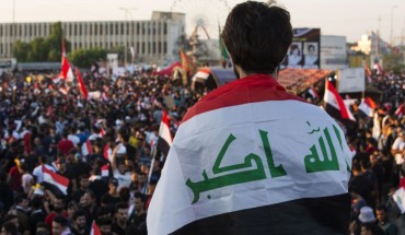 An Iraqi protester deaped in his national flag takes part in an anti-government protest in the southern city of Basra on November 1, 2019.