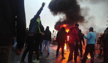 Iranian protesters gather around a fire during a demonstration against an increase in gasoline prices in the capital Tehran, on November 16, 2019. 