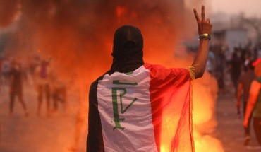 An Iraqi protester gestures the v-sign during a demonstration against state corruption, failing public services and unemployment at Tayaran square in Baghdad on October 2, 2019.