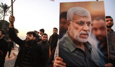 Supporters of the predominantly Shia Muslim Popular Mobilization Forces (PMF) gather with flags and posters of the PMF deputy head Abu Mahdi al-Muhandis during an anti-US protest after the US airstrike in Baghdad