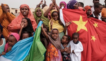 People hold Chinese and Djiboutian national flags as they wait for the arrival of Djibouti's President Ismail Omar Guellehas before the launching ceremony of new 1000-unit housing contruction project in Djibouti, on July 4, 2018. - The new 1000-unit construction project by the Ismail Omar Guelleh Foundation for Housing is financially supported by China Merchant, the operation parther of newly inaugurated Djibouti International Free Trade Zone (DITTZ) with Djibouti Ports and Free Zones Authority, to build ba