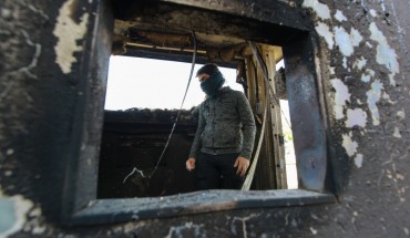  A protester stands inside a burned checkpoint during the sit-in against deadly US airstrikes on sites of a Shiite militia in front of the US embassy. Iraqi mourners on Tuesday stormed the building of the US embassy in Baghdad's heavily fortified Green Zone.