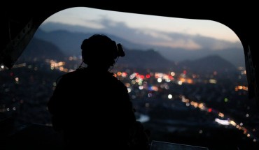 A US Army serviceman sits at the tailgate of an helicopter carrying US Defence Secretary, after leaving the Resolute Support headquarters, in the Afghan capital Kabul on April 24, 2017.