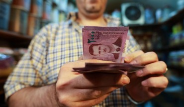 A merchant counts Syrian pound notes, bearing a portrait of the Syrian President Bashar al-Assad, at the Bzourieh market in the centre of the Syrian capital Damascus on September 11, 2019. 