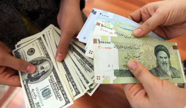 This picture illustrates Iranians on January 12, 2012 counting and exchanging the United States 100-dollar bills and Iran's Rial banknotes, bearing a portrait of Iran's late founder of Islamic Republic Ayatollah Ruhollah Khomeini in Tehran. The Rial's plunge, to 18,000 to the dollar hit a record low on January 18, based on rates in black market trading that the government has tried to ban.