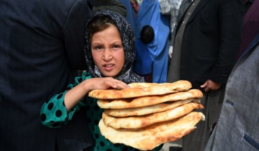 Young Afghan girl holding bread. 