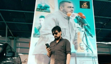 National Defense Commander Abdel Qader Hamo and behind him a picture of Ali Al-Yasiri, the leader of the concrete 