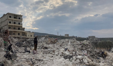 Cover photo: A man watches on as a family sifts through their destroyed home looking for blankets and clothes. Photo by Gregory Waters.