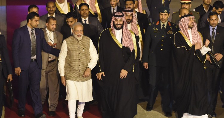 Saudi Crown Prince Mohammed bin Salman walks next to Indian Prime Minister Narendra Modi upon arriving at the airport in New Delhi on February 19, 2019.